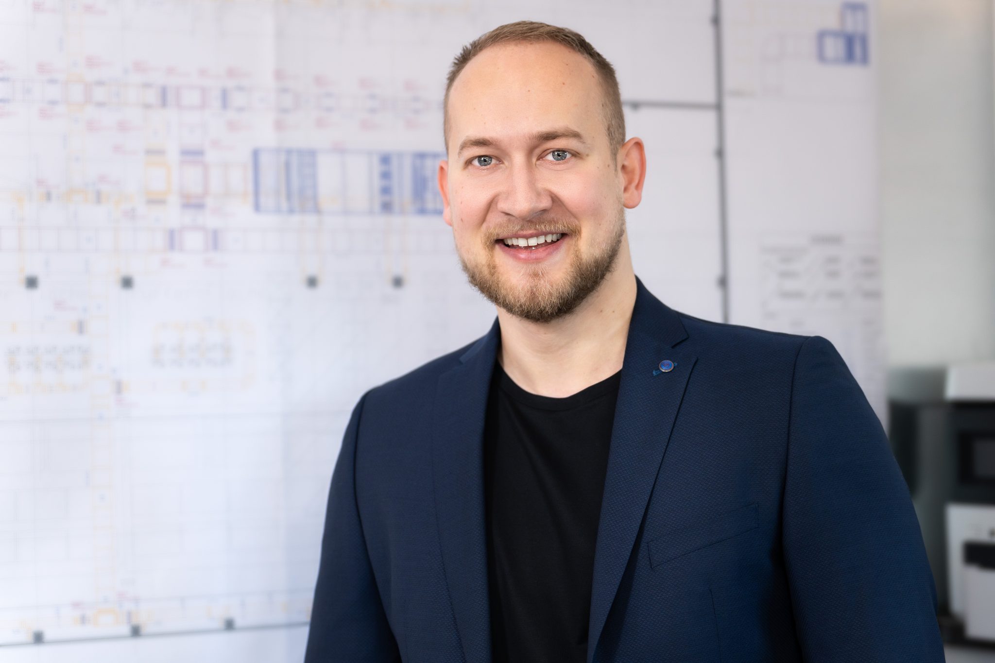 Michael Brunnbauer, Geschäftsführer Planungsbüro Brunnbauer, vor technischen Zeichnungen